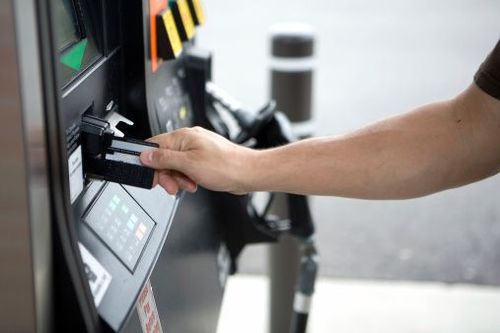 a man enters his credit card in the Fueling dispenser